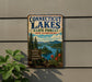 A vintage-style metal sign for Connecticut Lakes State Forest in New Hampshire, featuring a scenic landscape with pine trees, mountains, and a lake.