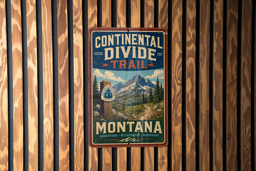 A vintage metal sign with the text "Continental Divide Trail Montana" hanging on a wooden wall.