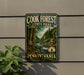 A vintage-style metal sign for Cook Forest State Park in Pennsylvania, featuring a scenic image of a forest and a river.