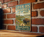 A vintage-style metal sign for Coteau Des Prairies, featuring a buffalo and a scenic landscape, is mounted on a brick wall.