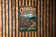 A vintage metal sign for the Cranberry Wilderness Trail in West Virginia, featuring a scenic view of a forest and a winding path.