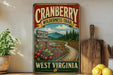 A vintage-style metal sign for the Cranberry Wilderness Trail in West Virginia, featuring a scenic view of a forest and a winding path.