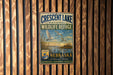 A vintage metal sign for the Crescent Lake National Wildlife Refuge in Nebraska, featuring a serene landscape with ducks and a sunset.