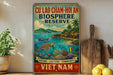 a vintage-style sign for the Cu Lao Cham-Hôan Biosphere Reserve, which is a nature reserve in Vietnam. The sign is displayed on a wall, surrounded by various objects such as a potted plant, a wooden cutting board, and some fruits like lemons.