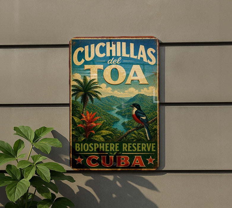 A vintage-style sign for the Cuchillas del Toa Biosphere Reserve in Cuba, featuring a tropical landscape with palm trees, a bird, and a river.