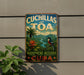 A vintage-style sign for the Cuchillas del Toa Biosphere Reserve in Cuba, featuring a tropical landscape with palm trees, a bird, and a river.