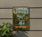 A vintage metal sign for Cummins Falls State Park in Tennessee, featuring a scenic image of the waterfall surrounded by lush greenery.