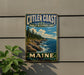 A vintage metal sign for Cutler Coast Public Reserve Land in Maine, featuring a scenic coastal landscape with rocky cliffs, pine trees, and a blue sky with clouds.