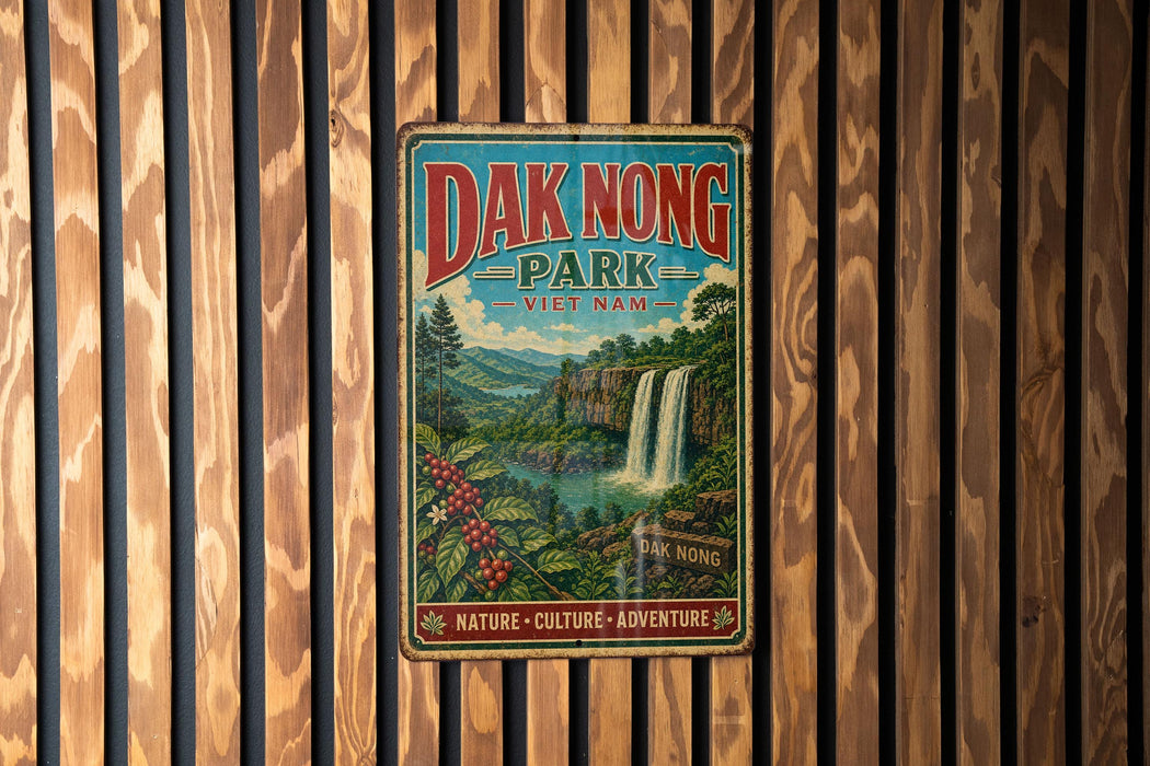 A vintage metal sign for Dak Nong Park in Vietnam, featuring a waterfall and lush greenery, is displayed on a wooden wall.