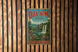 A vintage metal sign for Dak Nong Park in Vietnam, featuring a waterfall and lush greenery, is displayed on a wooden wall.