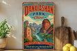 A vintage-style sign for Danxiashan Park, China, featuring a scenic mountain landscape with a river and boats.