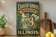A vintage-style sign for David Davis mansion in Bloomington, Illinois, featuring an illustration of the mansion surrounded by trees and flowers.