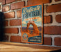 A vintage-style metal sign advertising the Delicate Arch Trail in Utah, featuring an illustration of the iconic rock formation.