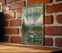 A vintage-style metal sign with the text "DESCHUTES NATIONAL FOREST OREGON EXPLORE DISCOVER WHERE ADVENTURE AWAITS" is displayed on a brick wall.