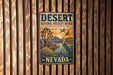 A vintage-style metal sign for the Desert National Wildlife Refuge in Nevada, featuring a desert landscape with a bird and a sunset.
