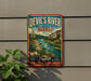 A vintage-style metal sign for Devil's River State Natural Area in Texas, featuring a scenic landscape with a river, mountains, and desert vegetation.