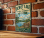 A vintage metal sign for Dewey Lake State Forest in Kentucky, featuring a scenic illustration of the lake surrounded by pine trees and mountains.
