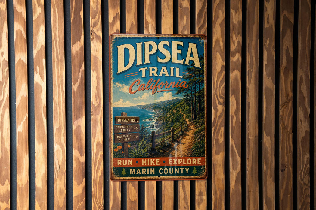 A vintage metal sign for the Dipsea Trail in California, featuring a scenic image of a trail surrounded by trees and a body of water.