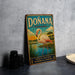 A vintage-style metal sign with a pink flamingo and a tropical landscape, featuring the text "DONANA ESPAÑA" and "PARQUE NACIONAL PATRIMONIO DE LA HUMANIDAD".