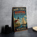A vintage metal sign advertising "Door County - Maritime Heritage Landscape" in Wisconsin, featuring a lighthouse and a sailboat on a body of water.