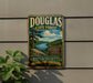 A vintage metal sign for Douglas State Forest in Massachusetts, featuring a scenic landscape with a lake and mountains.
