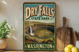 A vintage-style sign for Dry Falls State Park in Washington, featuring a scenic image of the falls and surrounding landscape.