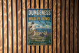 A vintage-style metal sign for the Dungeness National Wildlife Refuge, featuring a lighthouse, birds, and a mountain landscape.