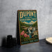 A vintage-style metal sign for DuPont State Recreational Forest, featuring a waterfall and lush greenery, is displayed on a gray concrete surface.