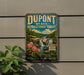 A vintage-style sign for DuPont State Recreational Forest, featuring a scenic landscape with waterfalls and flowers.