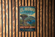 A vintage metal sign for El Hierro Park in Spain, featuring a scenic landscape with mountains, a tree, and a body of water.