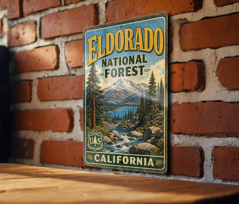 A vintage-style metal sign for Eldorado National Forest in California, featuring a scenic landscape with mountains, pine trees, and a river.
