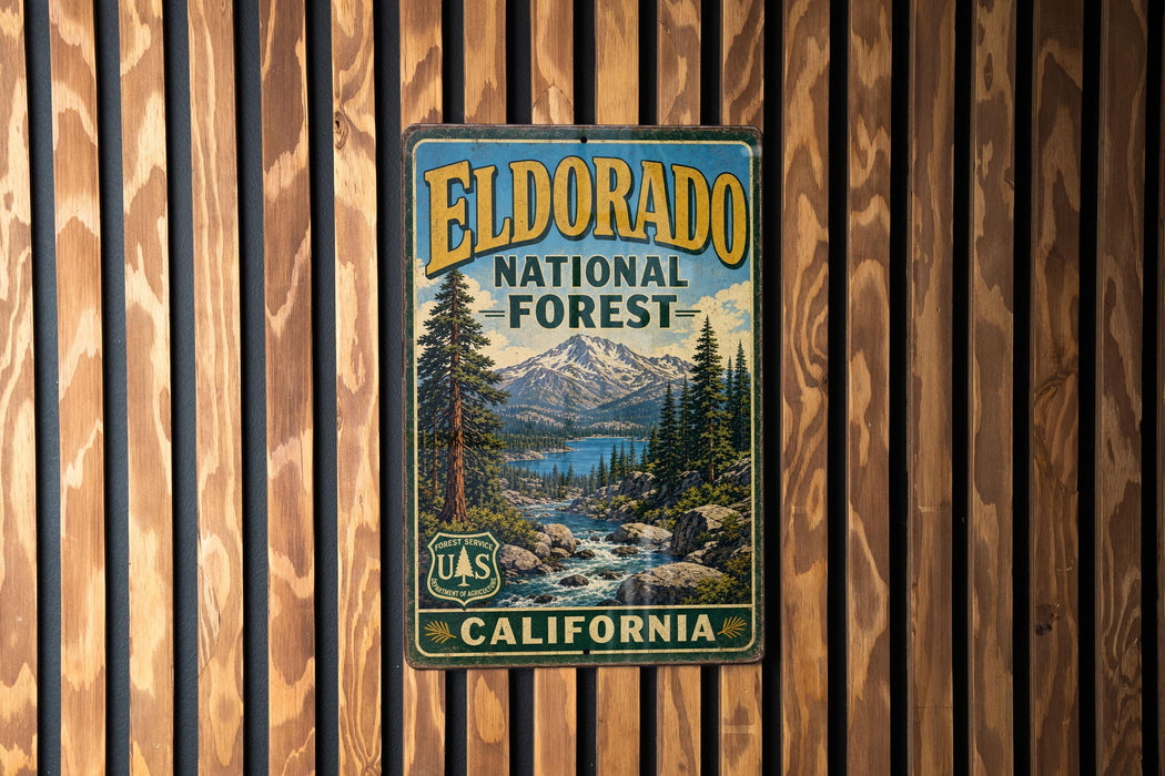 A vintage metal sign for the Eldorado National Forest in California, featuring a scenic landscape with a mountain, pine trees, and a river.