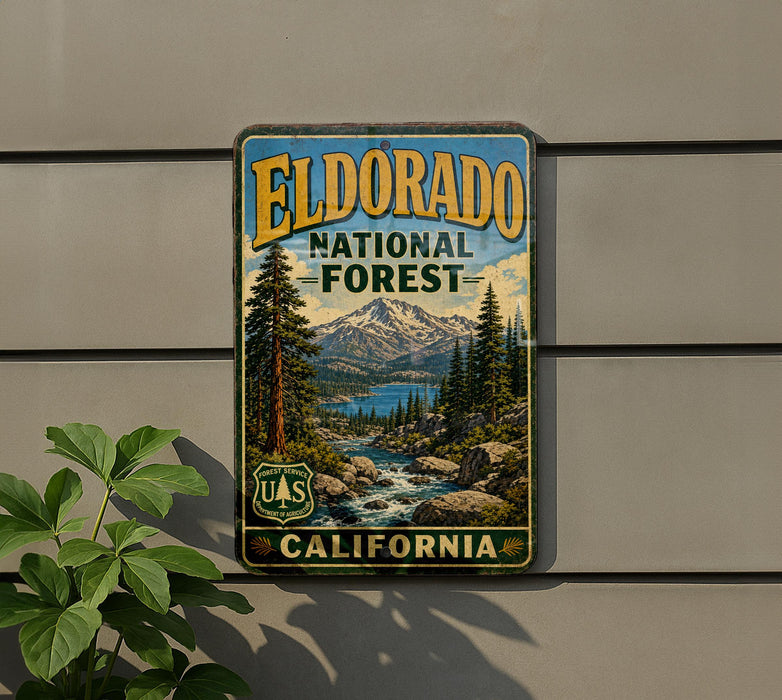 A vintage-style metal sign for the Eldorado National Forest in California, featuring a scenic landscape with mountains, pine trees, and a river.