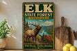 A vintage-style metal sign for the Elk State Forest in Pennsylvania, featuring an illustration of a large elk standing in a scenic forest landscape.