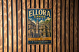 A vintage metal sign with the text "ELLORA CAVES INDIA" and "ANCIENT WONDERS A HERITAGE OF INDIA" is displayed on a wooden wall.