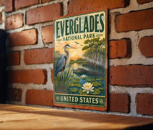 A vintage-style metal sign for Everglades National Park, featuring an illustration of a bird, a water lily, and a crocodile, is mounted on a brick wall.