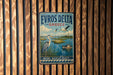 A vintage metal sign with the text "EVROS DELTA GRECE" and an illustration of a seagull, a boat, and a lighthouse, hanging on a wooden wall.