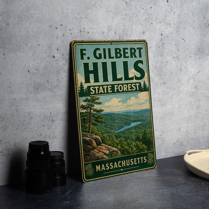 A vintage metal sign for F. Gilbert Hills State Forest in Massachusetts, featuring a scenic landscape with a river and pine trees.