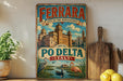 A vintage-style metal sign for the city of Ferrara, Italy, featuring a castle, a flamingo, and a boat on a river.