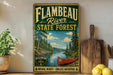 A vintage-style sign for the Flambeau River State Forest in Wisconsin, featuring a canoe and a scenic landscape.