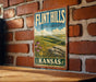 A vintage-style sign for "Flint Hills Cultural Landscape Kansas" is displayed on a brick wall.