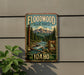 A vintage-style metal sign for the Floodwood State Forest in Idaho, featuring a scenic mountain landscape with a river and pine trees.