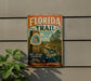 A vintage-style metal sign for the Florida Trail, featuring a scenic illustration of a trail surrounded by palm trees and a house.