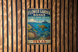 A vintage-style metal sign for the Flower Garden Banks National Marine Sanctuary in Texas, featuring an illustration of a turtle swimming among coral and fish.