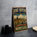 A vintage-style metal sign for Fort Benton National Historic Landmark in Montana, featuring an illustration of a castle and a river.