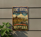 A vintage-style sign for Fort Benton National Historic Landmark in Montana, featuring a castle, river, and boat, mounted on a gray wall.