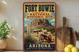 A vintage-style sign for Fort Bowie National Historic Site in Arizona, featuring a desert landscape with a mountain, a house, and a cannon.