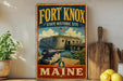 A vintage-style metal sign for Fort Knox, Maine, featuring an illustration of the fort and a cannon, with the text "Fort Knox State Historic Site" and "MAINE" prominently displayed.
