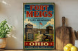 A vintage-style sign for the Fort Meigs State Memorial in Ohio, featuring a wooden fort with a cannon and a sign that reads "A Heroic Fortress of the Northwest 1819".