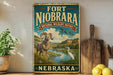 A vintage-style sign for the Fort Niobrara National Wildlife Refuge in Nebraska, featuring an illustration of a ram and a white egret in a scenic landscape.